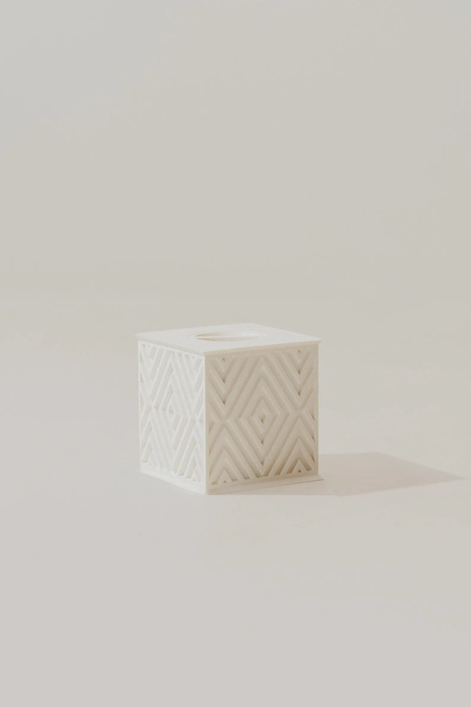 White textured memorial urn with geometric pattern on a light beige background