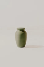 Olive smooth memorial urn on a light beige background