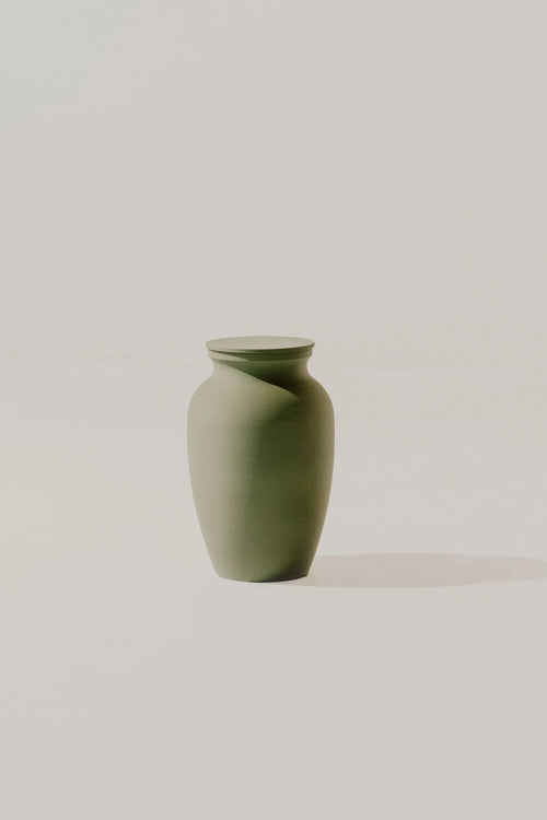 Olive smooth memorial urn on a light beige background