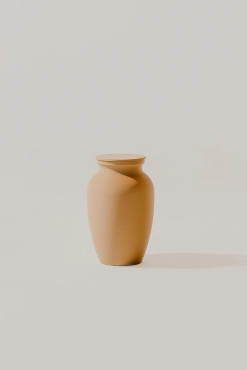 Brown smooth memorial urn on a light beige background
