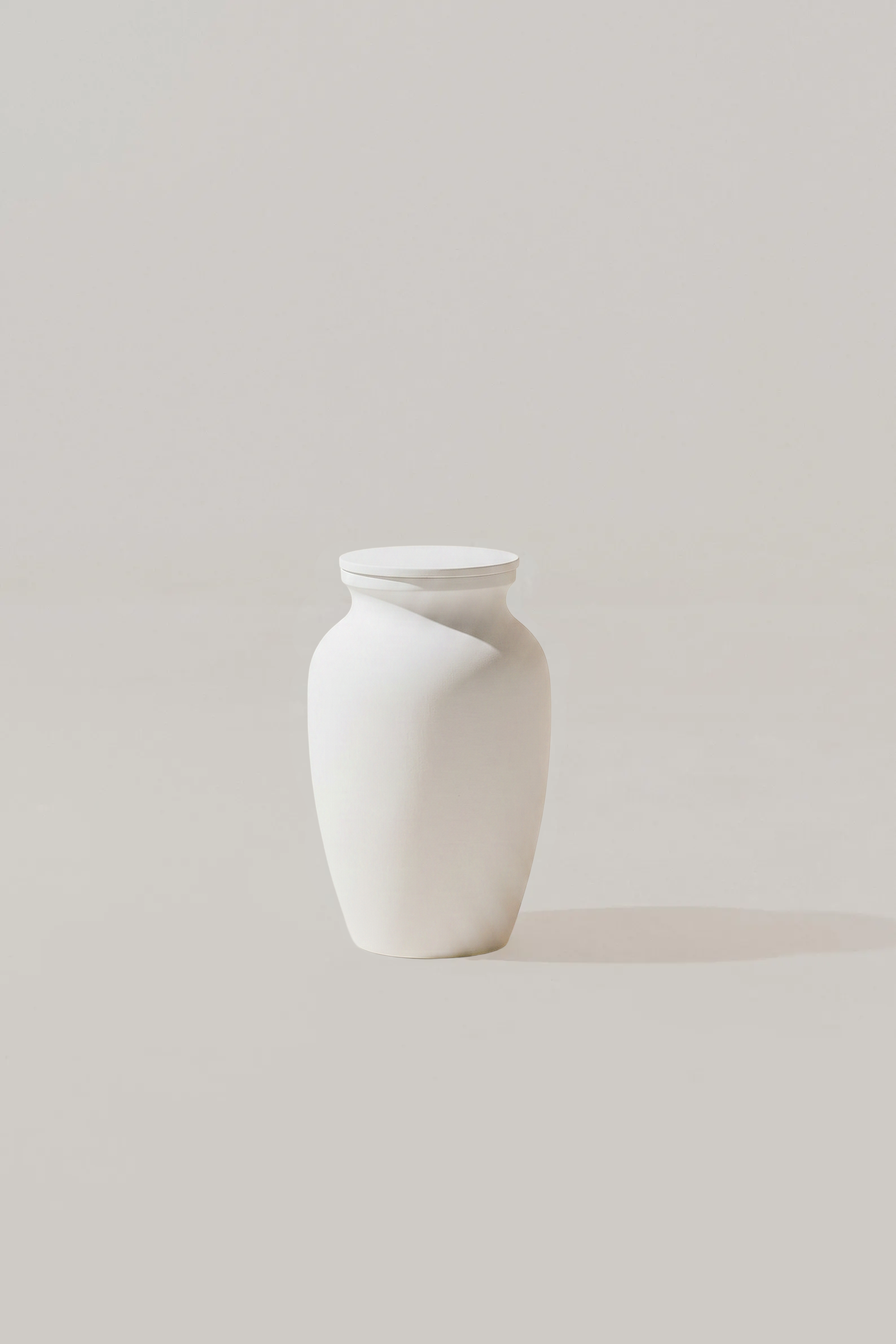 White smooth memorial urn on a light gray background