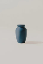 Blue smooth memorial urn on a light gray background