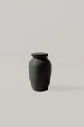 Black smooth memorial urn on a light gray background