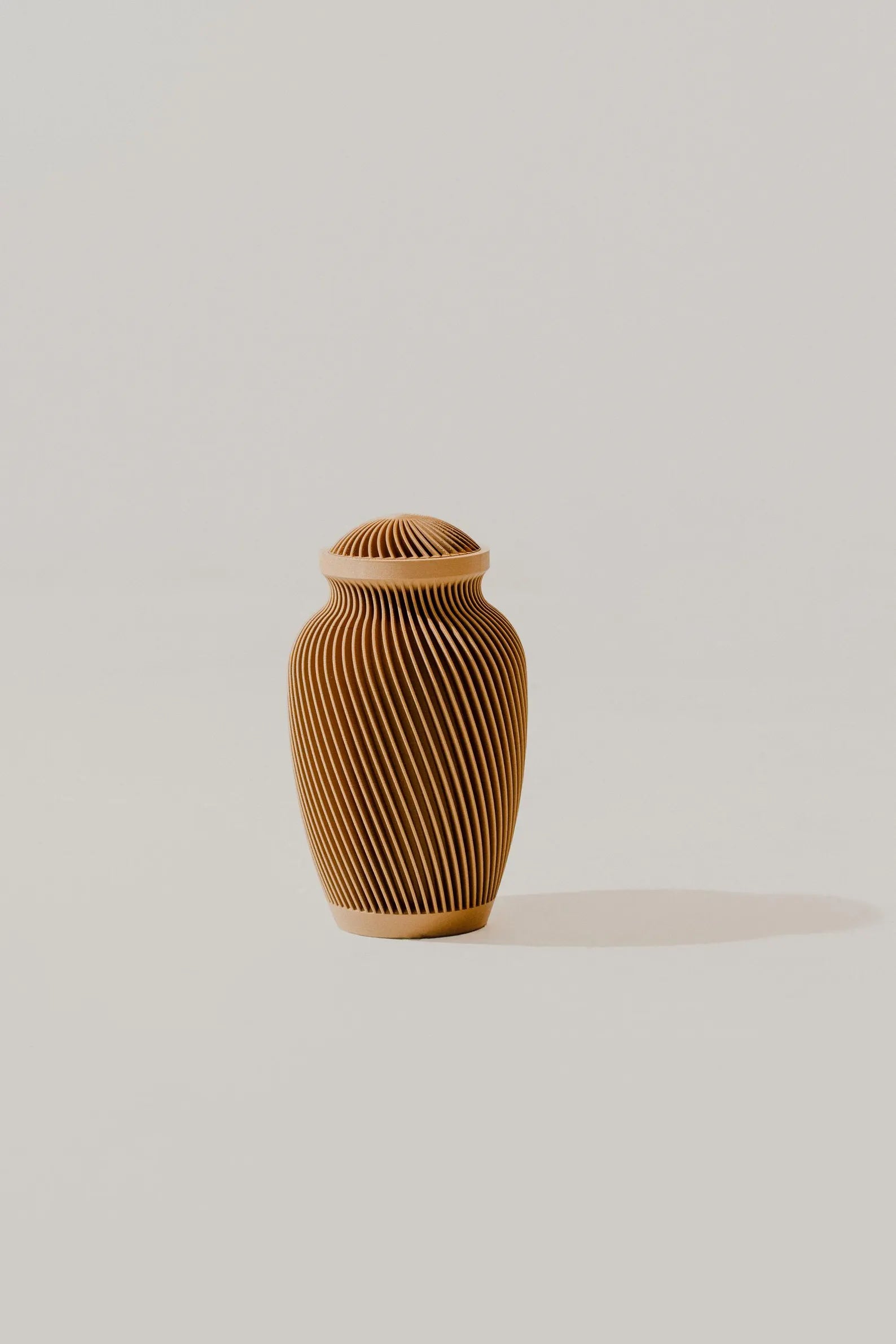 Brown textured memorial urn on a white background