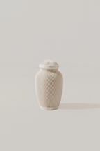 White ivory memorial urn with textured surface on a light gray background