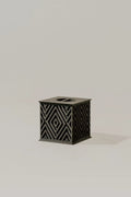 Beautiful black memorial urn with geometric pattern on a light gray background