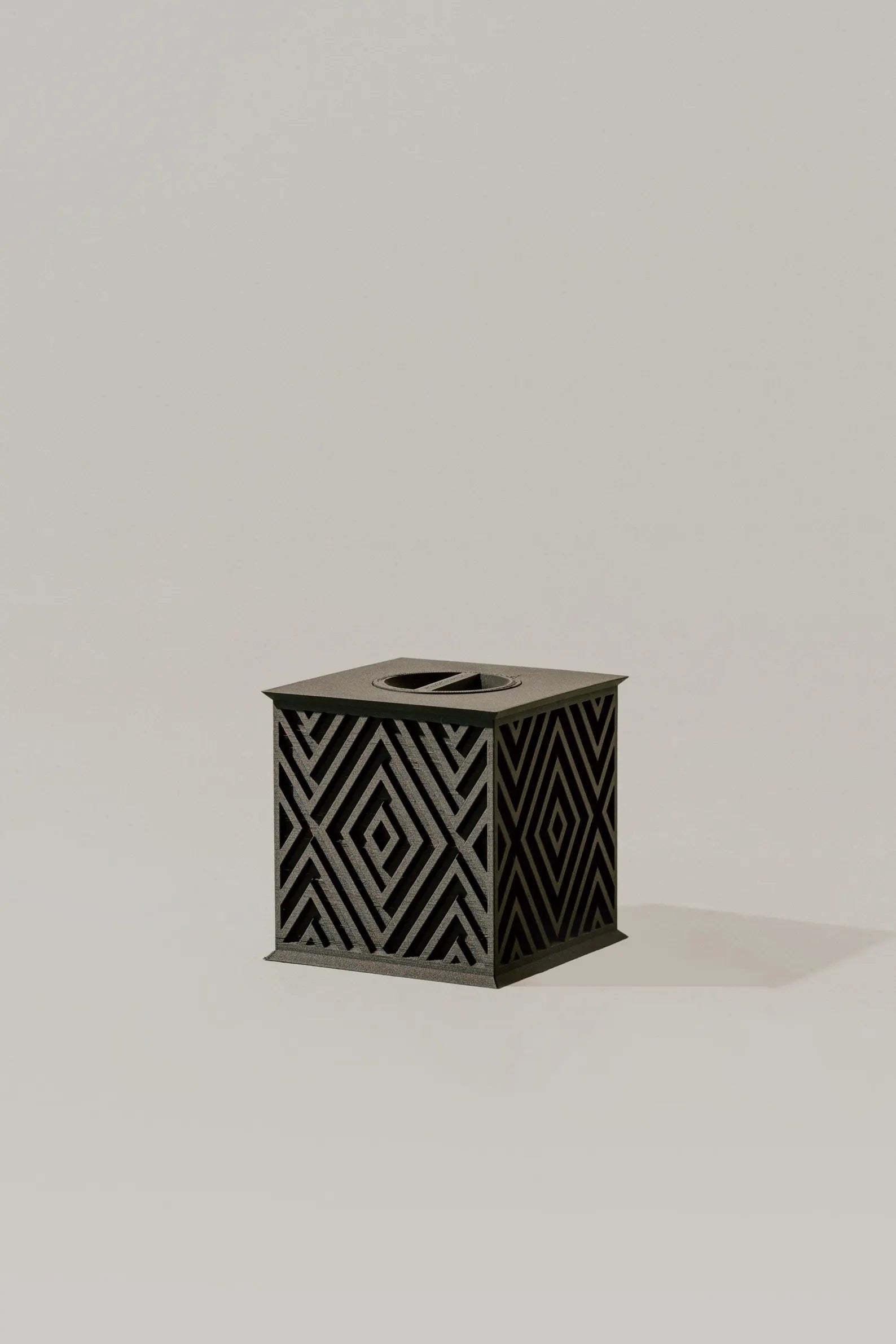 Beautiful black memorial urn with geometric pattern on a light gray background