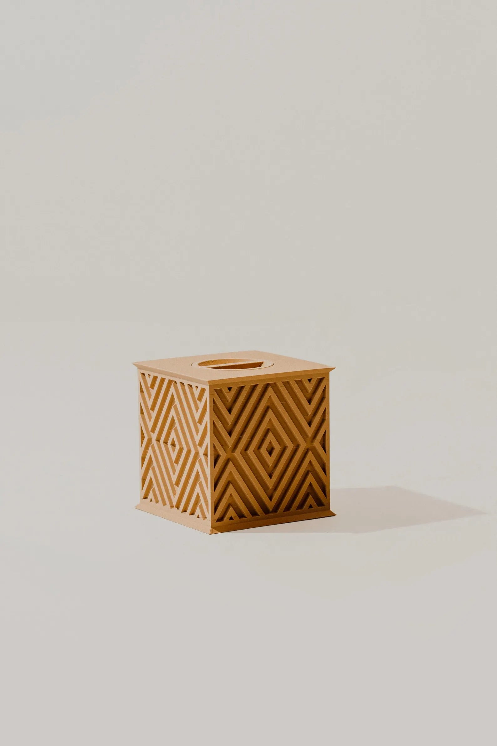 Beautiful sand wood memorial urn with geometric pattern on a light gray background