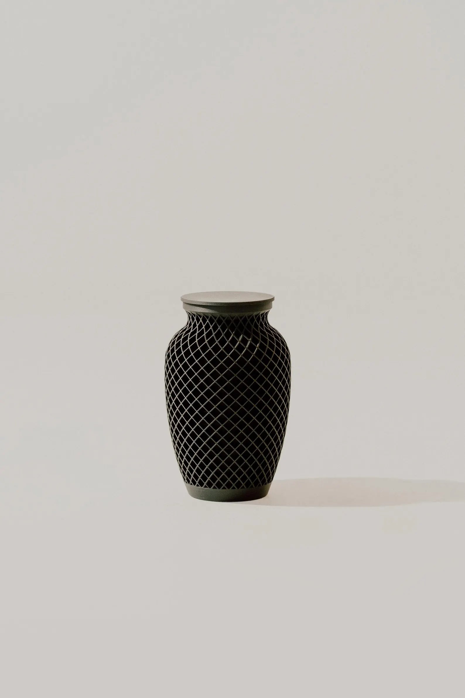 Black textured memorial urn on a light gray background